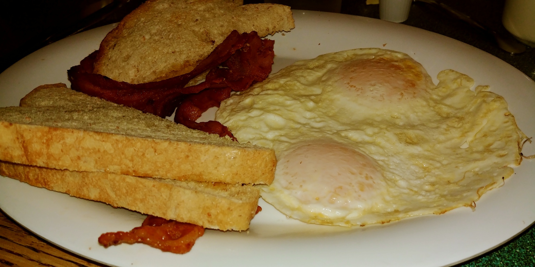 Ottumwa Iowa Hotels eggs, bacon, and toast on a plate.
